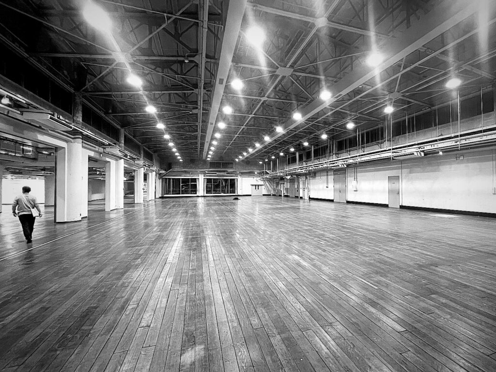 写真:撤収を終えて空っぽになったKIITOホールと078KOBEの屋台骨・事務局長の後ろ姿
